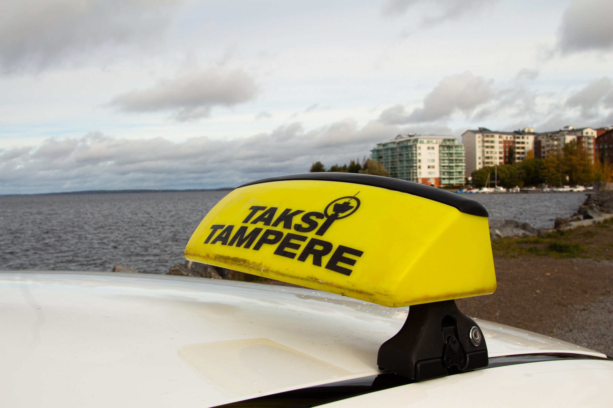 Kuvassa auton katolla keltainen taksikupu, jossa lukee Taksi Tampere